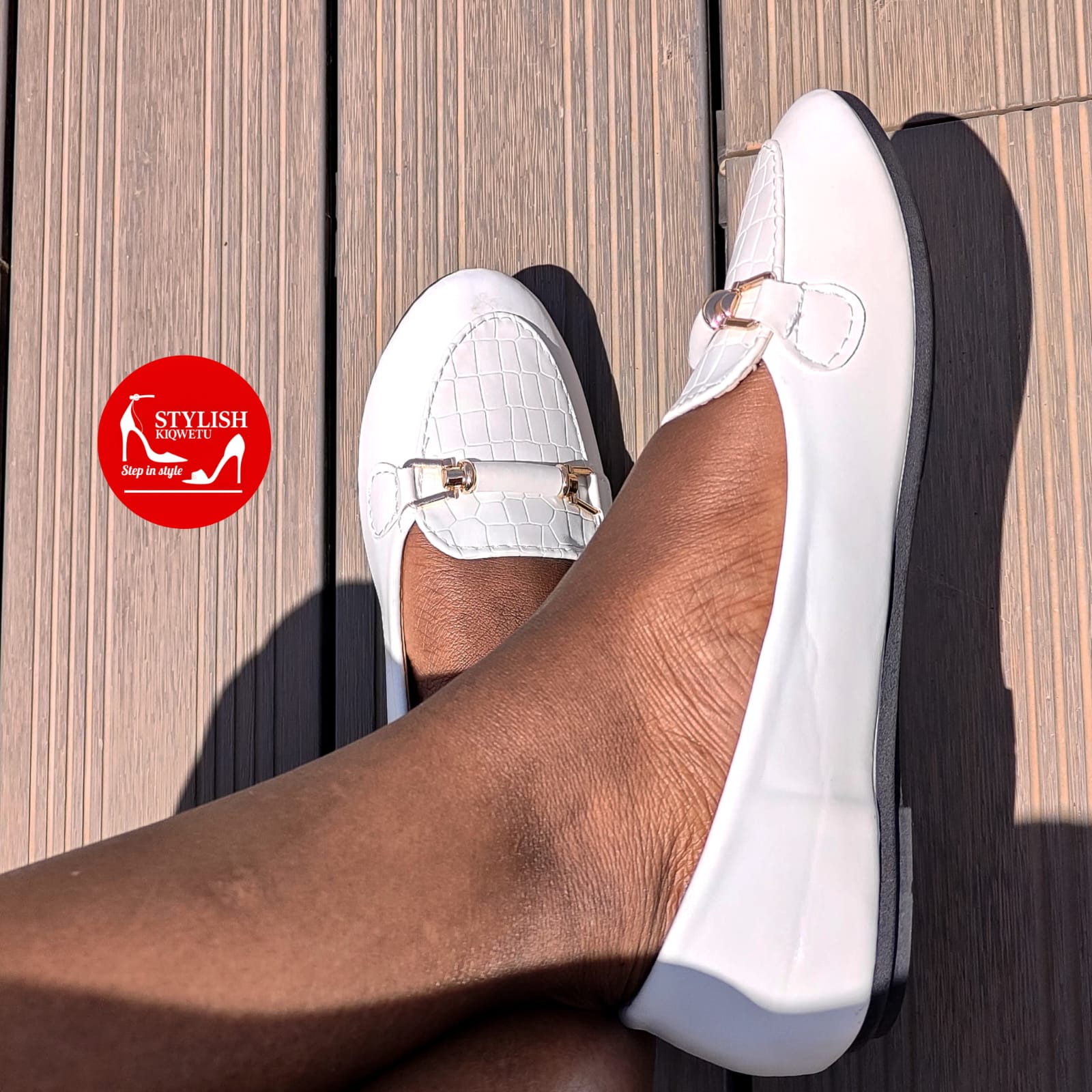 white crocodile-textured flat shoes.